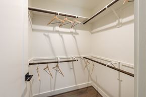 Katy apartment for rent - a spacious closet with white walls and a row of hangers