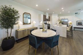 Katy apartment for rent - a dining area with a round table and blue chairs and a kitchen in the background