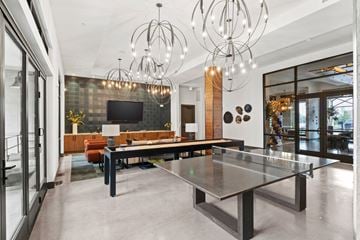 Addison apartment for rent - A modern living room with a glass table and a television.