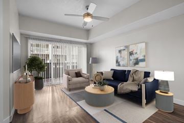Salt Lake City apartment for rent - A living room with a blue couch and a ceiling fan.
