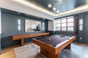 Jersey City apartment for rent - A pool table is in the middle of a room with a bench and a mirror.