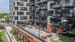 Minneapolis apartment for rent - A modern apartment complex with a pool and lounge area.