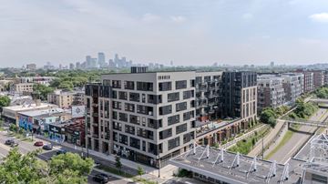 Minneapolis apartment for rent - A modern multi-story building with a parking structure in front of it.