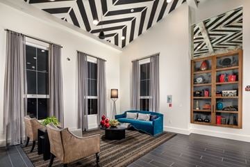 San Mateo apartment for rent - A living room with a blue couch and a black and white striped ceiling.
