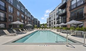 Wilton apartment for rent - a swimming pool with umbrellas in front of an apartment building