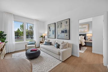 North Attleborough apartment for rent - A living room with a couch, a chair, a table, and two paintings on the wall.