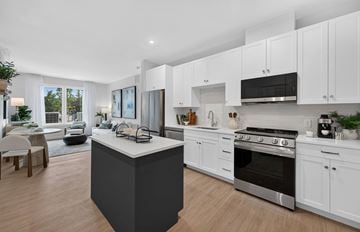 North Attleborough apartment for rent - A modern kitchen with white cabinets and a black island.