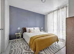 Boston apartment for rent - Model bedroom with floor to ceiling window, blue fabric accent wall, and modern decor