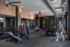 Marlborough apartment for rent - a woman walking through a gym filled with weights and cardio equipment