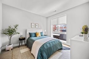 Somerville apartment for rent - a bedroom with a medium sized bed and a large window