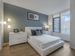 Boston apartment for rent - a bedroom with a bed and a dresser in front of a window