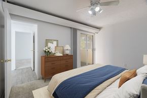 Albuquerque apartment for rent - A bedroom with a bed, dresser, and sliding glass doors.