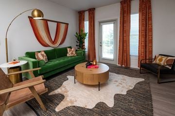 Lenexa apartment for rent - A living room with a green couch and a wooden coffee table.