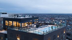 Denver apartment for rent - a large building with a pool on top of it overlooking a city