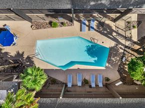 Tucson apartment for rent - Aerial view of outdoor pool with lounge chairs and shaded seating area.