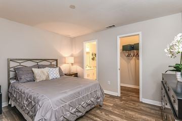 Orlando apartment for rent - A bedroom with a large bed and a wooden floor.