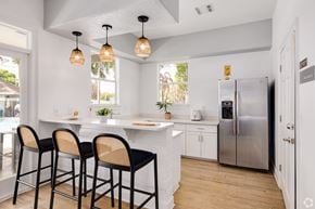 Orlando apartment for rent - A kitchen with a white counter and black bar stools.