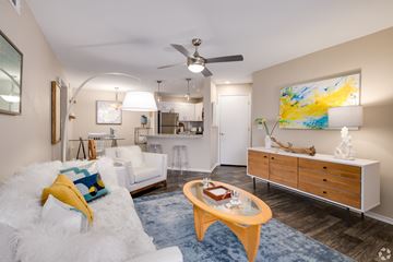 Orlando apartment for rent - A living room with a white couch and a yellow pillow.