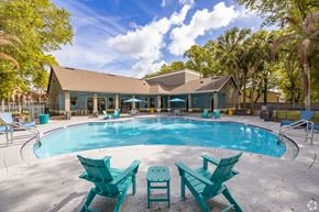 Orlando apartment for rent - A pool surrounded by chairs and trees.