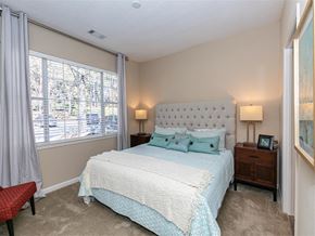 Johns Creek apartment for rent - A bedroom with a large bed and a window with curtains.