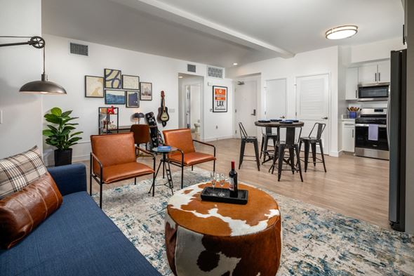 El Monte apartment for rent - large living room with cow ottoman and open kitchen at Aston at Gateway apartments in El Monte, California