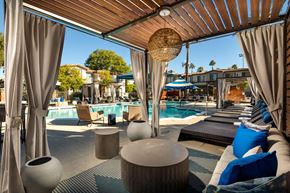 Palm Desert apartment for rent - A poolside lounge area with blue cushions and a wooden ceiling.