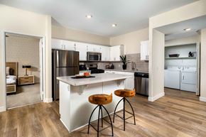 Palm Desert apartment for rent - A kitchen with white cabinets and a wooden floor.