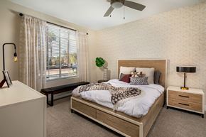 Palm Desert apartment for rent - A bedroom with a large bed, a ceiling fan, and a window with blinds.