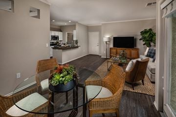 Riverside apartment for rent - A modern living room with a glass table and chairs.