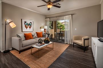 Riverside apartment for rent - A living room with a grey couch, a coffee table, a television, and a painting on the wall.