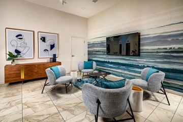 Long Beach apartment for rent - a living room with blue chairs and a wall mural of the ocean