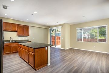 Spring Valley apartment for rent - A kitchen with wooden cabinets and a black countertop.