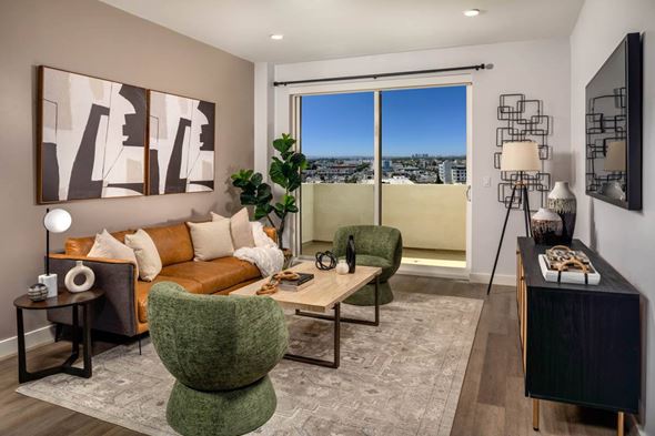 Culver City apartment for rent - A living room with a green chair and a brown couch.