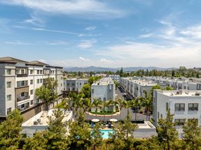 Escondido apartment for rent - A view of apartment buildings with a pool in the foreground.