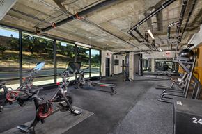 Monrovia apartment for rent - A gym with a row of stationary bikes and a weight rack.