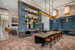 Santa Ana apartment for rent - a dining room with a long table and chairs and a kitchen with blue walls