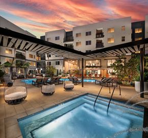 Santa Ana apartment for rent - a swimming pool at night with an apartment building in the background