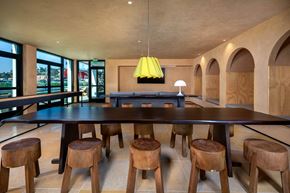 Los Angeles apartment for rent - A long wooden table with matching chairs is in the middle of a room with a yellow lamp hanging from the ceiling.