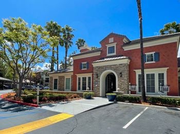 Reserved carport parking in front of a brick building with palm trees