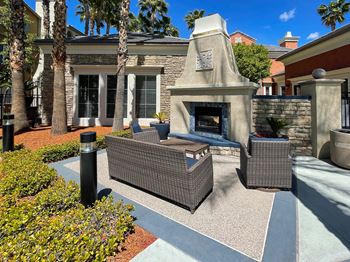 Patio with a fireplace and wicker furniture in front of a lounge