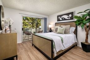 Pomona apartment for rent - A bedroom with a large bed and a wooden dresser.