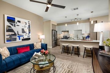 Rancho Cucamonga apartment for rent - A modern living room with a blue couch and a glass coffee table.