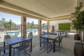 Lancaster apartment for rent - A patio with a table and chairs overlooking a pool.
