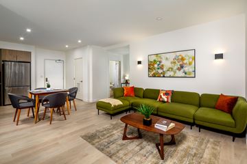 Los Angeles apartment for rent - A modern living room with a green couch and a wooden coffee table.