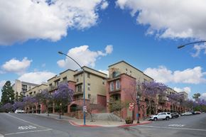 San Diego apartment for rent - A street view of a residential area with apartment buildings and parked cars.