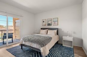 San Diego apartment for rent - A bedroom with a large bed and a view of the outside.