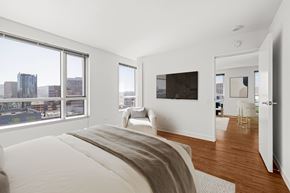 San Francisco apartment for rent - A bedroom with a large bed and a city view through the window.