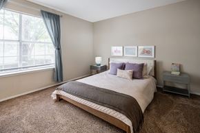 Memphis apartment for rent - A bedroom with a large bed and a window with curtains.