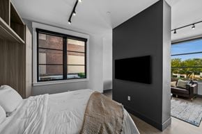 Salt Lake City apartment for rent - A modern bedroom with a large bed and a flat screen TV.
