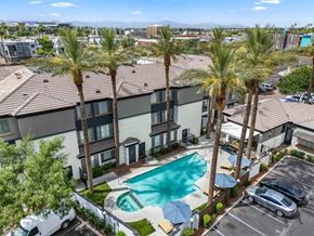 Phoenix apartment for rent - A swimming pool surrounded by palm trees and apartment buildings.